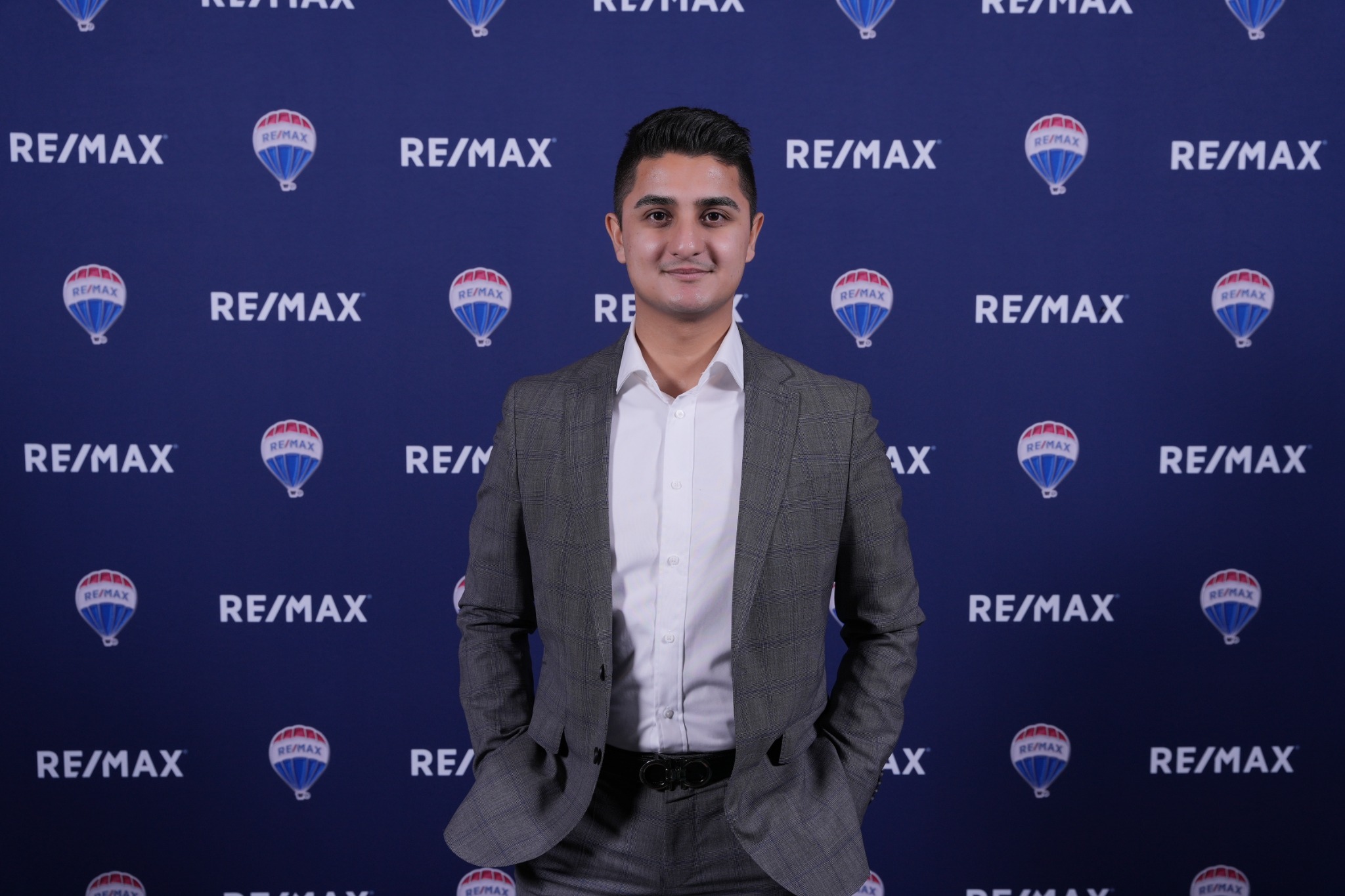 Zain Jafrey, real estate broker, in front of a RE/MAX backdrop